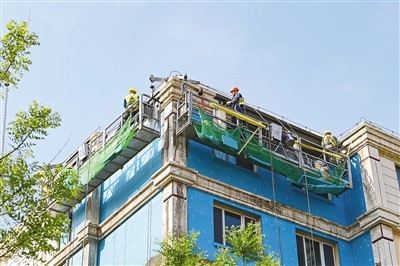 内蒙古自治区呼和浩特市在老旧小区改造过程中推动城市社区嵌入式服务设施建设，为社区居民提供养老托育、社区助餐、家政便民等服务。图为施工人员在该市赛罕区明和园老旧小区改造现场作业。王 正摄（人民视觉）