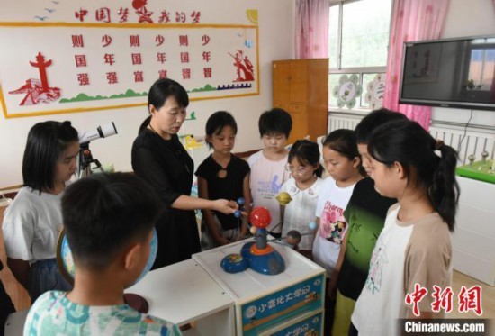 图为河北省深州市兵曹乡兵曹完全小学，航天员蔡旭哲的姐姐蔡旭娜(左三)为学生们讲解航天知识。袁佳凯 摄