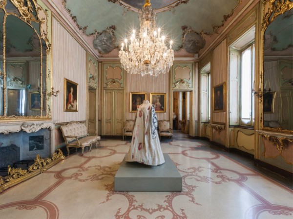 a person in a dress in a room with a chandelier