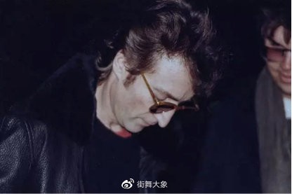 1980年12月8日，列侬遇害前几个小时，为行凶者查普曼（右）签名