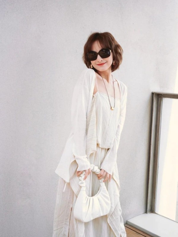 a person wearing a white dress and sunglasses