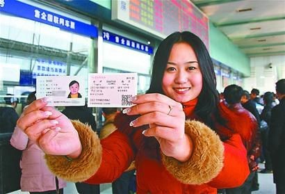 1月1日，一名旅客在扬州火车站售票大厅内展示自己的身份证和购买的实名制火车票。当日起，覆盖全国所有车次的火车票实名制在全国范围内开始实施。 新华社发□本报记者 林江丽 