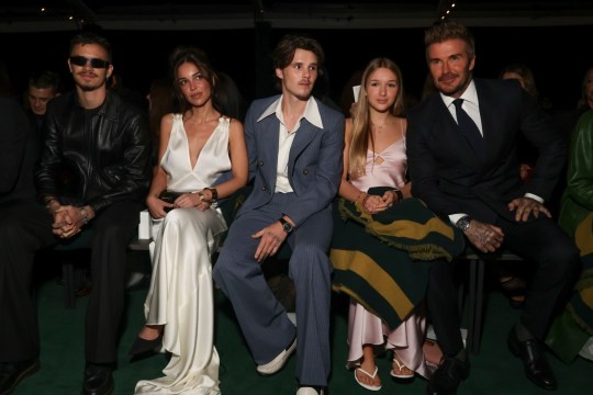 Romeo Beckham, from left, Jackie Apostel, Cruz Beckham, Harper Beckham, and David Beckham sit front row at a Paris Fashion Week show