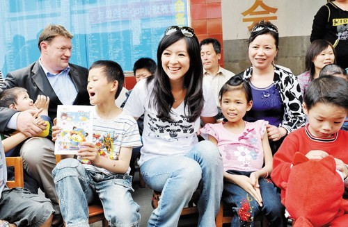 2009年5月,经历“诈捐门”后的章子怡在英国关爱儿童慈善组织陪同下,看望福利院孩子。