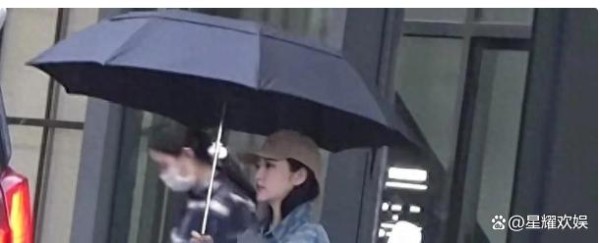 景甜在雨天与助理外出，独自撑伞，助理则在雨中奔跑淋湿