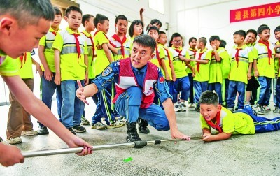5月7日，红十字会工作人员在湖南省永州市道县第四小学为学生们指导防溺水救援技能。