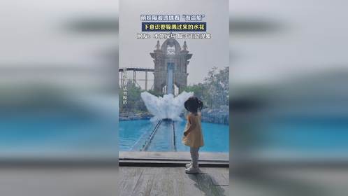 萌娃隔着玻璃看“海盗船”，下意识要躲溅过来的水花。