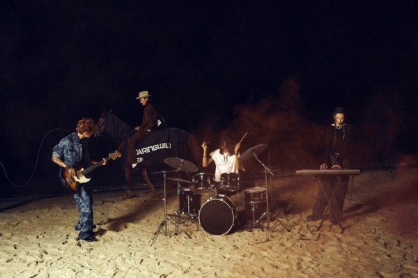 a group of people playing instruments on a beach