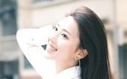 这姑娘穿着白衬衫，背着包，笑得真甜