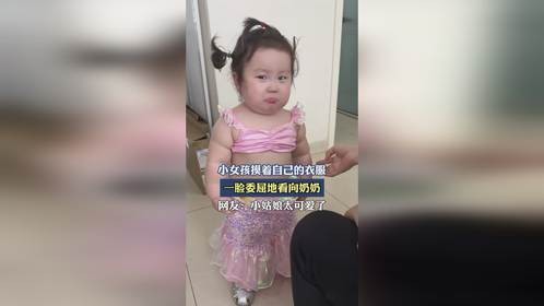 小女孩摸着自己的衣服，一脸委屈地看向奶奶。