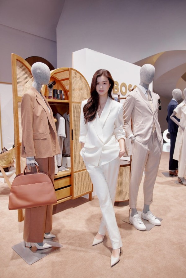 a person posing in front of a display of mannequins