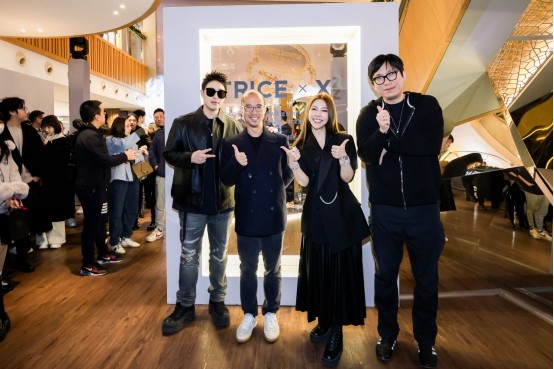 group of individuals posing together at an event with a display in the background