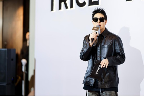 a speaker holding a microphone and a notepad with the word trice