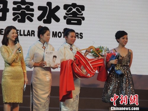 军旅著名歌唱演员陈思思在慈善晚会现场捐献自己一件大红色旗袍和新录制的《献礼祖国》专辑，两件物品现场拍价22万。秦洁摄