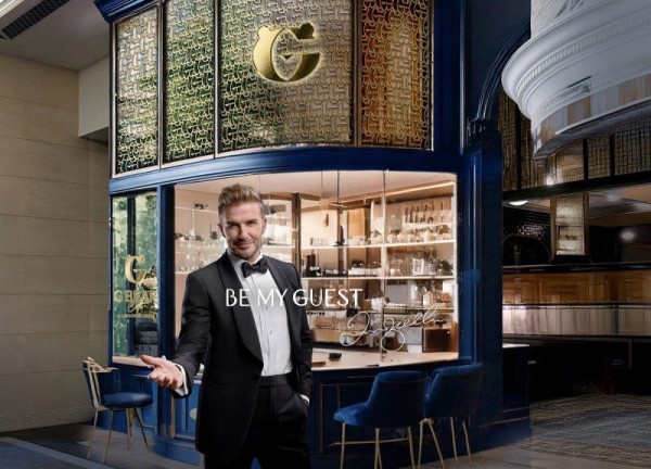 elegantly dressed host inviting guests at a bar with a sophisticated interior