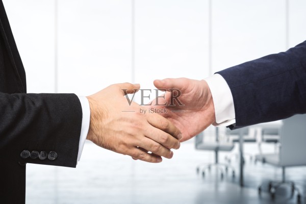明亮的会议室背景上两位商人握手，合作理念，合拍图片