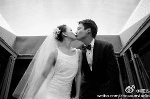 穿着婚纱的周迅与高圣远亲吻。