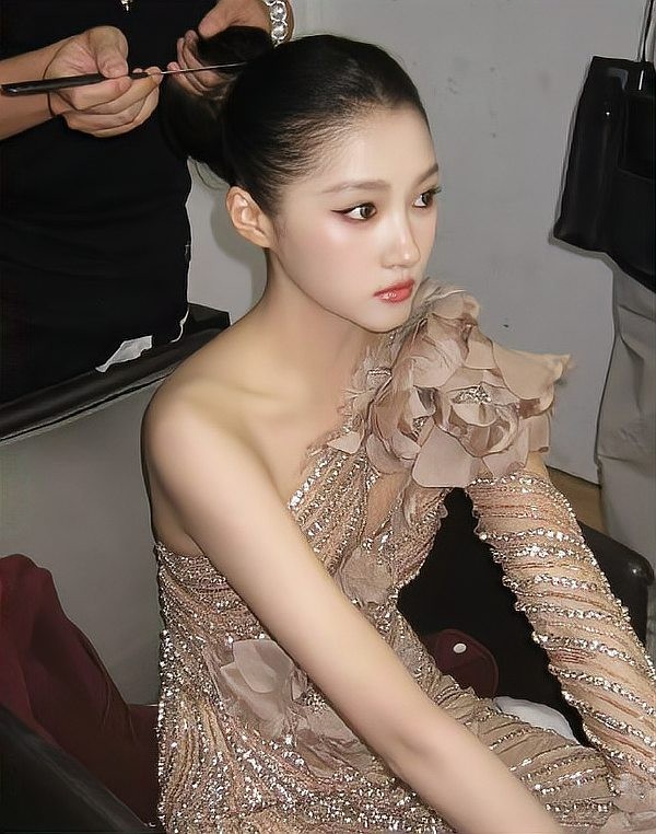 关晓彤明星化妆准备中，穿着华丽礼服的女性模特。