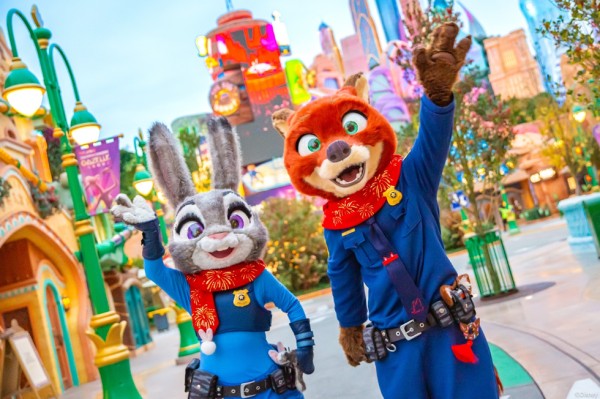 two cartoon animal characters posing in a vibrant theme park setting