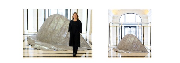 a person standing in front of a large sculpture