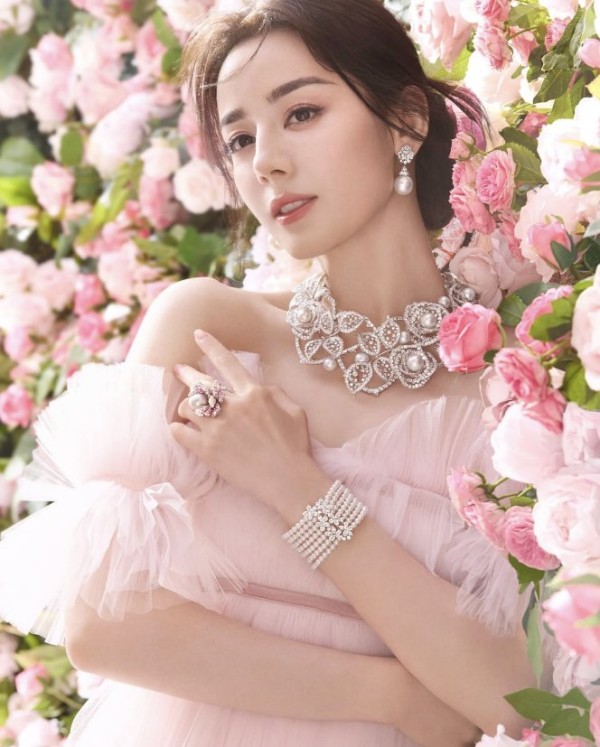 迪丽热巴优雅女性佩戴华丽珠宝， surrounded by pink花朵