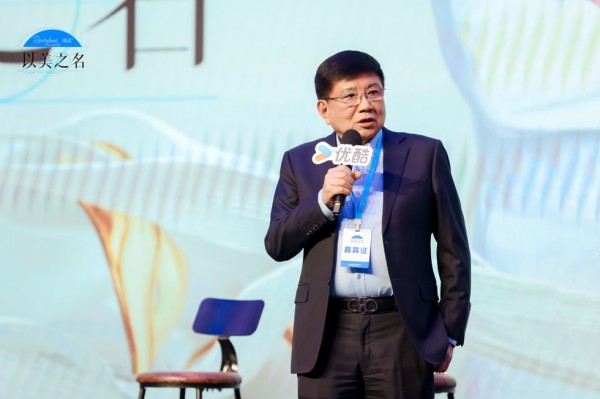 speaker at an event with a branded sign and backdrop