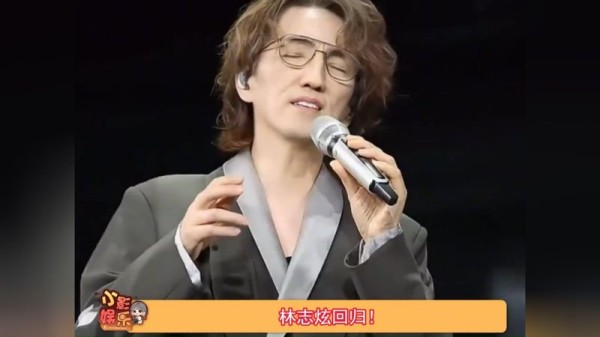 林志炫一位男士在舞台上用麦克风表演，屏幕底部显示“林志炫回归！”的字幕。