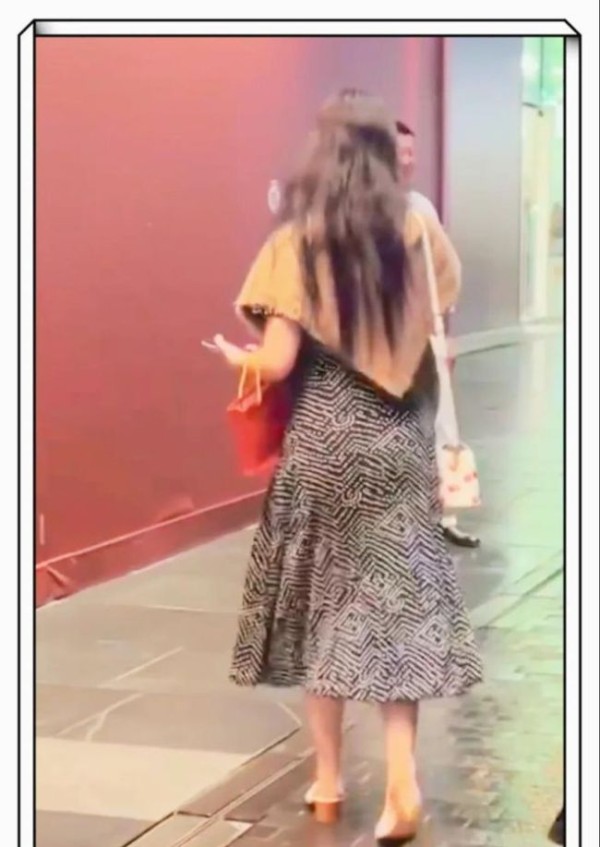 “女性在地铁站内低头看手机”