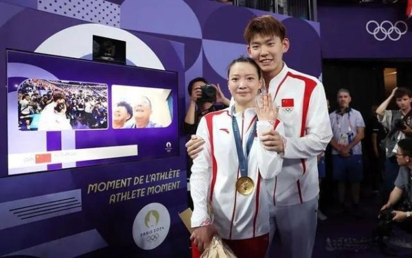 刘雨辰黄雅琼中国奥运选手领奖合影，背景显示“ATHLETE MOMENT”字样
