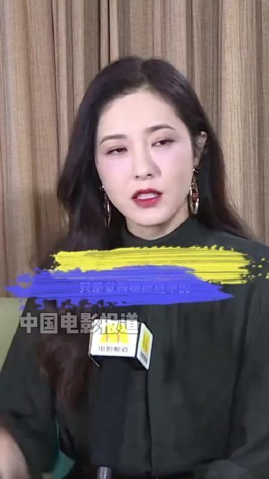 曾黎采访中的女性嘉宾，背景为木质幕布，带有“央视新闻”标志的麦克风。