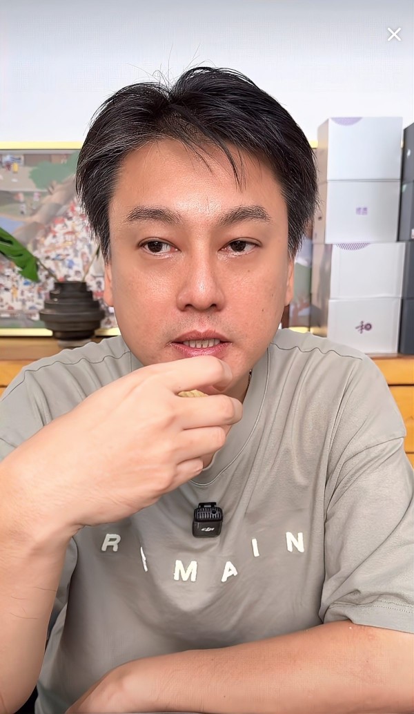 朱孝天“男子在餐厅用餐，身穿印有字母的灰色T恤”