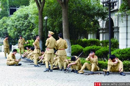 昨日，群众演员们在拍戏间隙躲到树荫下“喘口气”