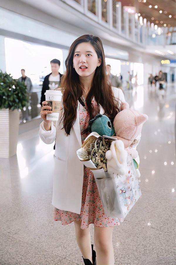 赵露思机场少女携带玩偶和咖啡，神色略显惊讶