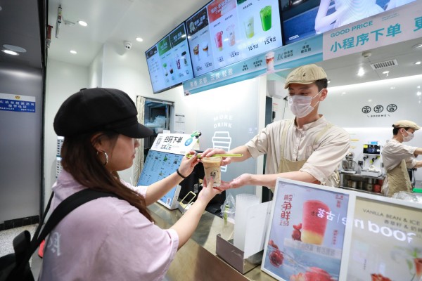 一家古茗门店，顾客正在取咖啡。企业供图