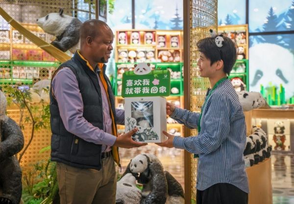 调研期间，肯尼亚国家广播公司新闻编辑、记者埃瑞克·比根收到了中方记者赠送的“花花”文创礼物。本报记者 伊霄 摄
