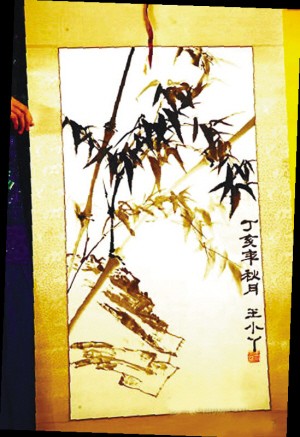 　　王小丫和她的国画作品（上图）。