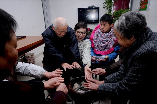 倪明华和安心居家老年公寓的老人们在一起,一家人取暖唠嗑