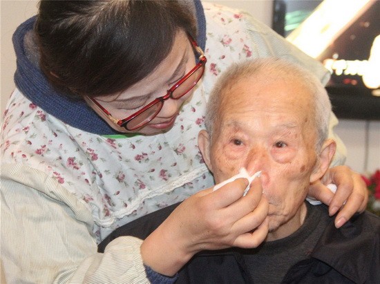 倪明华象女儿一样,给老人喂饭喂菜,清理擦洗,悉心照顾。