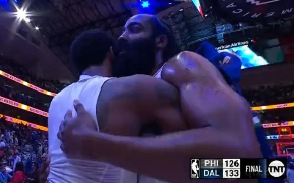 独行侠球员凯里-欧文和76人球员詹姆斯-哈登在场边拥抱致意