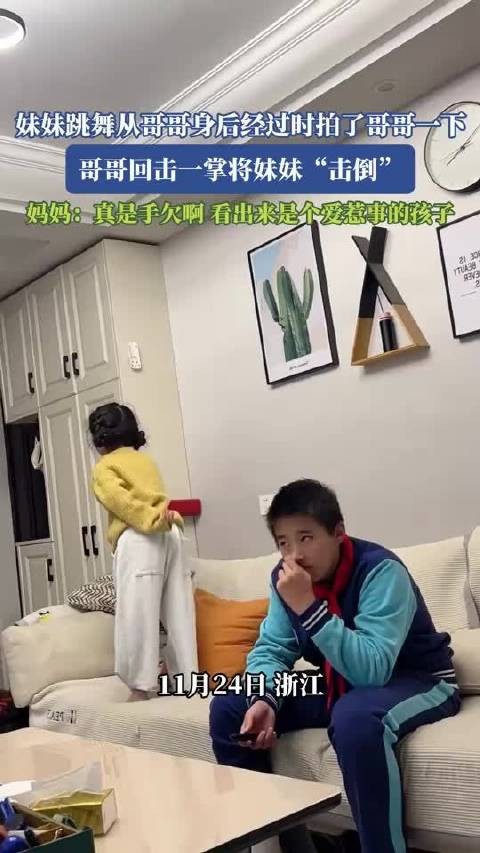 妹妹跳舞从哥哥身后经过时拍了哥哥一下,哥哥一掌将妹妹“击倒”