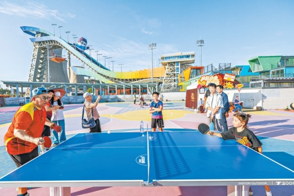 大满贯公园内,球迷在首钢滑雪大跳台下交流球技。