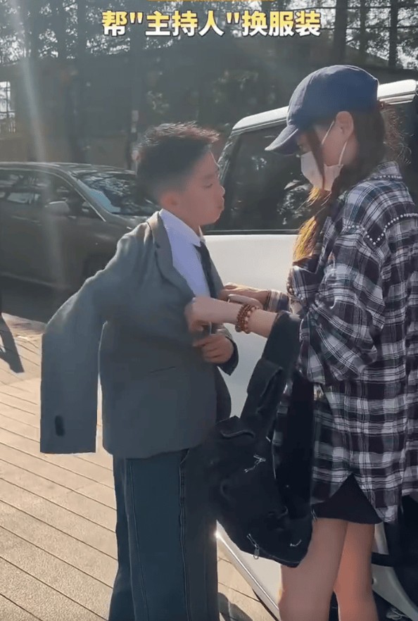 应采儿帮儿子穿衣服。