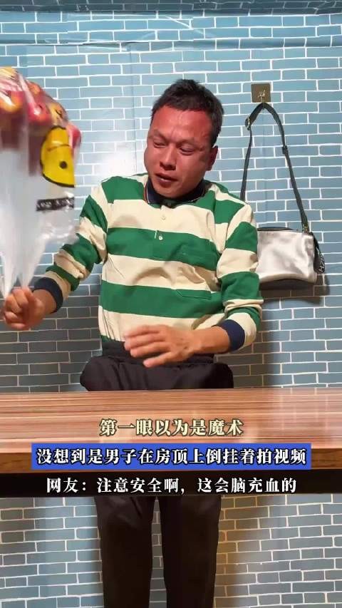 第一眼以为是魔术，没想到是男子在房顶上倒挂着拍视频