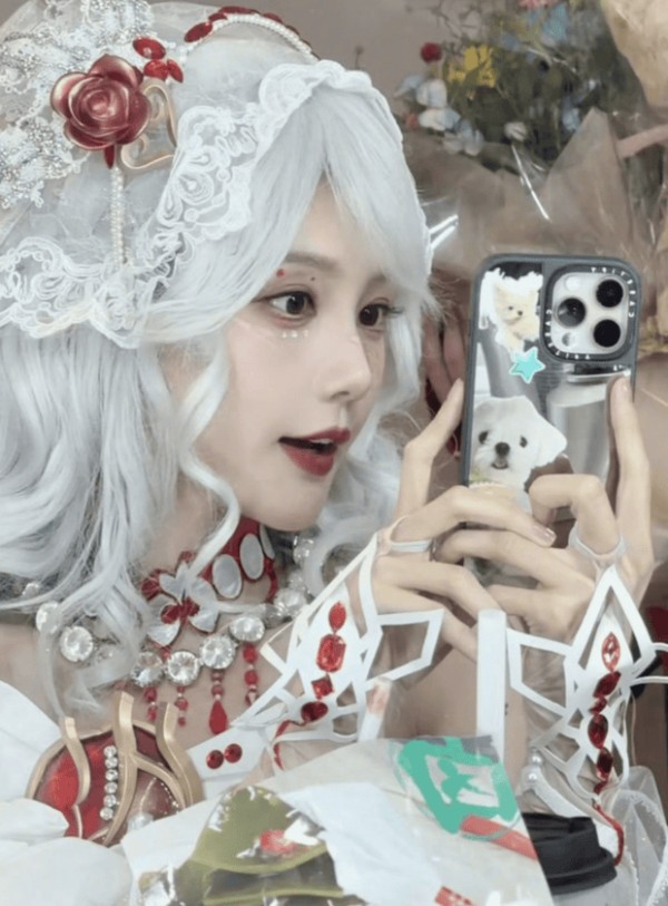 李一桐对镜手机自拍，神态俏皮灵动，甜艳中藏着可爱感。