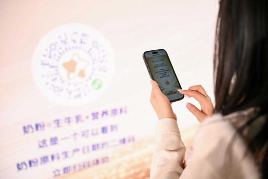 用户活动现场手机扫码体验，飞鹤全球首个奶粉新鲜原料溯源系统