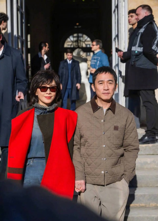 刘嘉玲挽梁朝伟牵手下楼,气场十足。