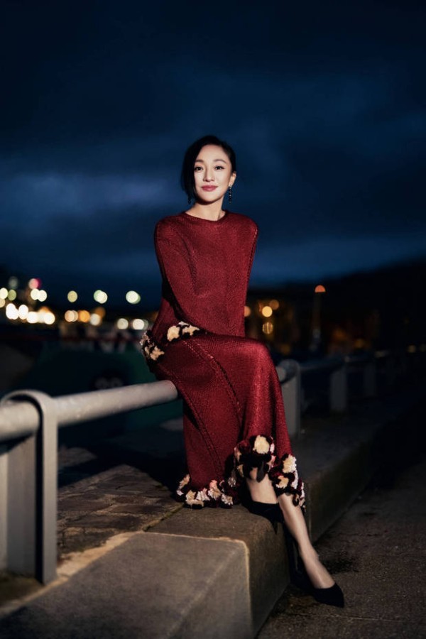周迅身着酒红针织长裙，浅笑间尽显优雅贵气。