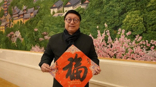 黄正明:执笔送“福”,温暖万千归途