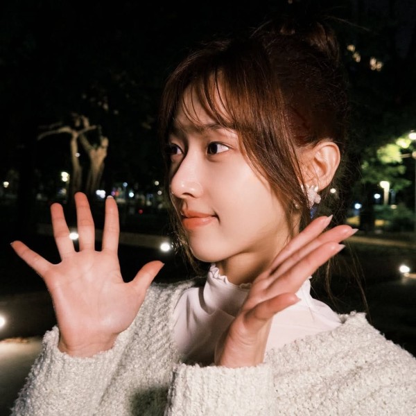 a person gesturing with both hands in an outdoor night setting