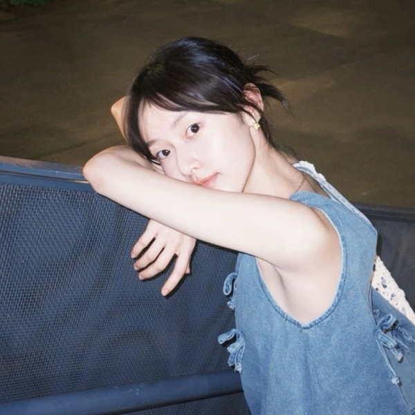 person resting arms on a railing at night